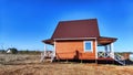 A small unfinished country house in the middle of a field. Building a new cottage in nature in the spring with good Royalty Free Stock Photo