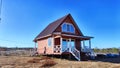 A small unfinished country house in the middle of a field. Building a new cottage in nature in the spring with good Royalty Free Stock Photo