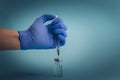 Small vaccine bottle phial and a medical syringe injection in a doctor`s or a scientist`s hand in medical gloves isolated on Royalty Free Stock Photo