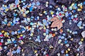 Small various stones, sand, soil with grass used as a background and base. A little green plants growing in the garden. Royalty Free Stock Photo