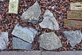 Small various stones, sand, soil with grass used as a background and base. A little green plants growing in the garden. Royalty Free Stock Photo