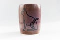 Small vase with an Egyptian cat made of red clay covered with transparent glaze. Ancient Egyptian hieroglyph. the glaze