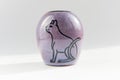 Small vase with an Egyptian cat made of red clay covered with transparent glaze. Ancient Egyptian hieroglyph. the glaze