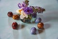 A small vase with spring flowers and painted quail Easter eggs . Royalty Free Stock Photo
