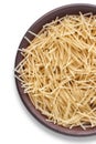 Small vermicelli in a brown clay bowl isolated on a white background. Raw pasta top view with copy space Royalty Free Stock Photo