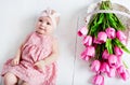 Small very cute, big-eyed little girl in a pink dress lying on a Royalty Free Stock Photo