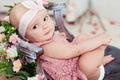 Small very cute wide-eyed smiling baby girl in a pink dress is i Royalty Free Stock Photo