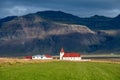 Small village with a church by the foot of a mountain