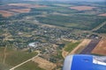 A small village, a green forest, yellow fields. View from the airplane