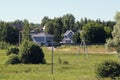 Small village with powerline poles and trees under a clear blue sky during daytime Royalty Free Stock Photo