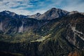 Small village surrounded by green mountains under a blue cloudy sky Royalty Free Stock Photo