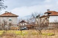 Small Village with Traditional Houses and Old Vehicles in a Poor Area in Bulgarian Countryside During Winter Season. Royalty Free Stock Photo