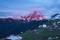 Small village under a snow-covered mountain ridge during sunset Royalty Free Stock Photo