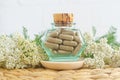 Small vintage bottle with herbal food supplement capsules and yarrow flowers. Natural healthcare and herbal medicine Royalty Free Stock Photo