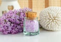 Small vintage glass bottle with purple bath salts epsom salt, foot soak and lilac flowers. Copy space