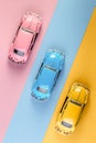 Small vintage retro toy cars on a pink, yellow and blue background Royalty Free Stock Photo