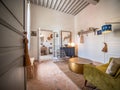 Small vintage room with a wicker chair, a bench, a vintage armchair, and a brick floor