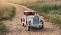 Small vintage style tin car on a dirt road. Old toy car. Collectible vehicle Royalty Free Stock Photo