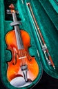 Small violin with bow in green velvet case Royalty Free Stock Photo