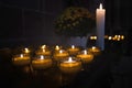 Votive or prayer candles burning as a votive offering in an act of Christian prayer inside of church Royalty Free Stock Photo