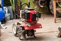 A small walk-behind tractor for plowing a garden is in the garage Royalty Free Stock Photo