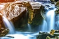 Small waterfall with blue foamy water on wet stones Royalty Free Stock Photo