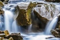 Small waterfall with blue foamy water on wet stones Royalty Free Stock Photo