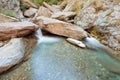 Small waterfall casdcading over rocks in blue pond Royalty Free Stock Photo