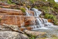 Small waterfall with clear water running over the rocks and ending in a small lake Royalty Free Stock Photo