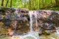 Clear water of a brook, flows over an old dam, built as torrent control Royalty Free Stock Photo