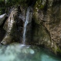 Small waterfall down the mossy rocks falling into a beautiful soca river