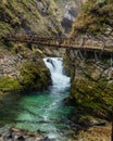 Small waterfall and emerald waters of Vintgar gorge with wooden elevated pathway