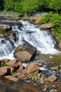 Small waterfall flowing down a rockface in the forest Royalty Free Stock Photo