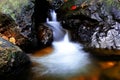 Small waterfall flowing over rocks in nature. Royalty Free Stock Photo