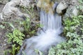 Small waterfall in the forest polluted with plastic bags and trashes Royalty Free Stock Photo