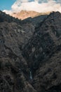 Small waterfall, huge mountains, shadows playing Royalty Free Stock Photo