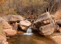 A small waterfall on the Left Fork Subway in Zion National park pours over sandstone boulders