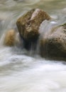 Small waterfall in the mountain river. Beautiful natural background of stones and with flowing, blurring water and foaming. Royalty Free Stock Photo