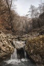A small waterfall on a mountain small river in a beautiful autumn forest Royalty Free Stock Photo