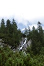 Small waterfall in the mountains surrounded by trees Royalty Free Stock Photo