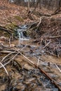A small waterfall in a natural creek area , running rapid with spring snow melt Royalty Free Stock Photo