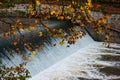 Small waterfall on the river Sihl in Zurich city Switzerland framed by fall colored tree leaves in late October Royalty Free Stock Photo