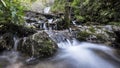 Small waterfall in the river surrounded by mossy rocks Royalty Free Stock Photo