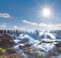 Waterfall on river under a sparkle sun Royalty Free Stock Photo