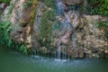 Small waterfall sliding over stone and moss