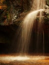 Small waterfall on small mountain stream, mossy sandstone block and water is jumping down into small pool. Water streams with Royalty Free Stock Photo