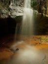 Small waterfall on small mountain stream, mossy sandstone block and water is jumping down into small pool. Water streams with Royalty Free Stock Photo