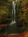 Small waterfall on small mountain stream, mossy sandstone block and water is jumping down into small pool. Water streams with Royalty Free Stock Photo