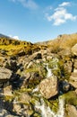 Small waterfall stream in nature. Water flowing through the rocks