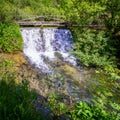 Small waterfall under a wooden bridge at the source of the Ebro river. Fontibre Cantabria Royalty Free Stock Photo